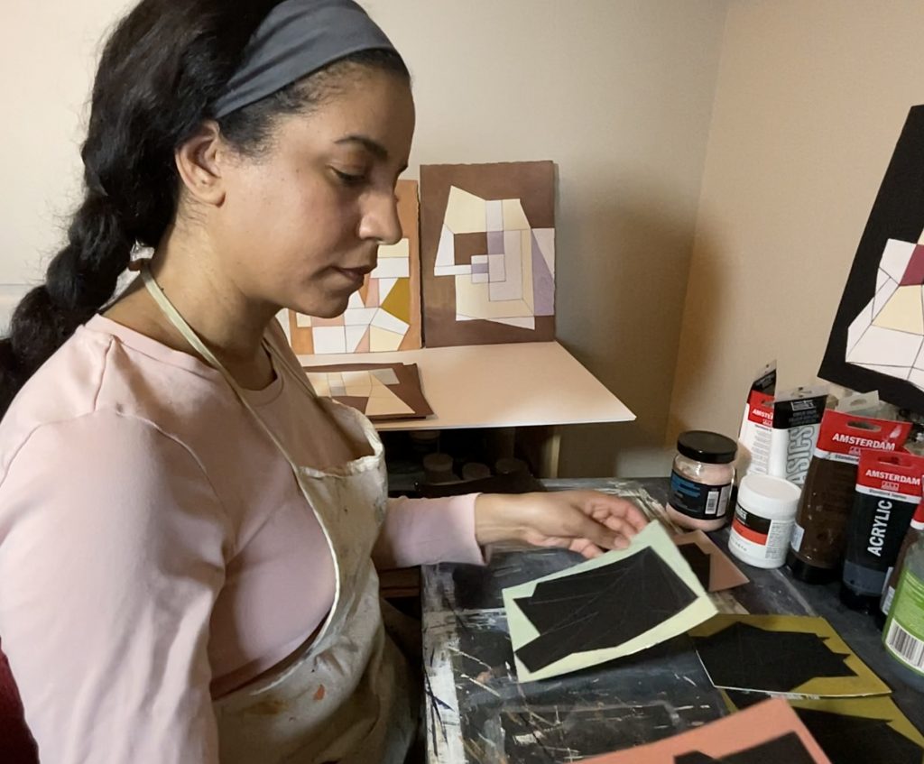 April Pyne in her studio, looking down at a drawing
